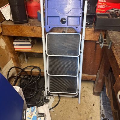 Sale Photo Thumbnail #105: Three-step folding step stool ladder featuring a white metal frame, black non-slip treads, and a top blue tool tray.