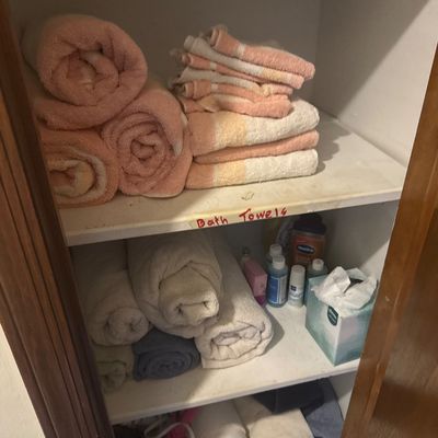 Sale Photo Thumbnail #42: Linen closet filled with assorted bath towels, washcloths, toiletries, and paper products.