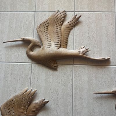 Sale Photo Thumbnail #45: Hand-carved wooden wall decor depicting a heron or crane in flight with detailed feather textures.