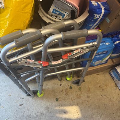 Sale Photo Thumbnail #106: Pair of folding medical walkers with front wheels and tennis balls on the back legs.