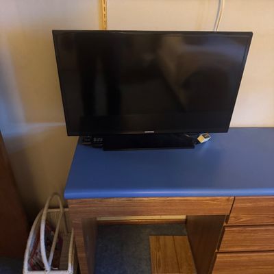 Sale Photo Thumbnail #51: Black Samsung flat-screen television resting on a wood laminate desk with a blue desktop.