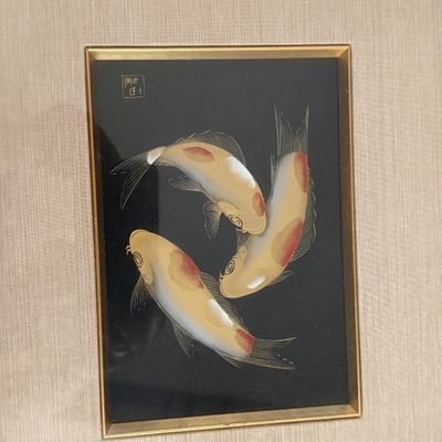 Framed Asian-style artwork featuring three koi fish swimming on a black background, complete with a fabric mat and wooden frame.