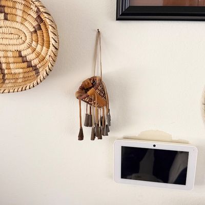 Sale Photo Thumbnail #149: Small woven miniature basket wall hanging with leather fringe and metal bell dangles.