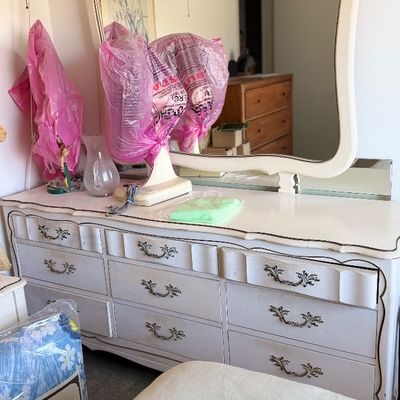 Sale Photo Thumbnail #115: French Provincial style white dresser with matching attached mirror, featuring intricate metal hardware and decorative carved trim.
