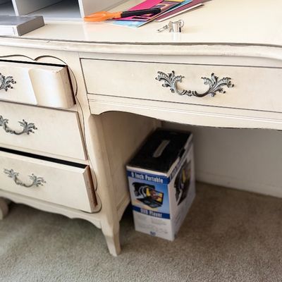 Sale Photo Thumbnail #105: Vintage French Provincial style off-white wooden desk featuring ornate metal drawer pulls and light wear.
