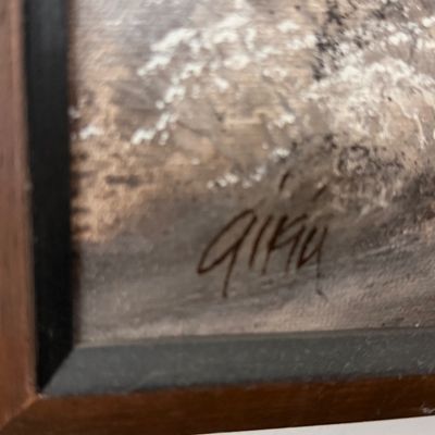 Close-up of an artist's signature on a framed painting.