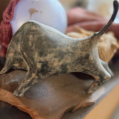 Mid-century modern bronze or cast iron bull figurine mounted on a natural wood slab base.