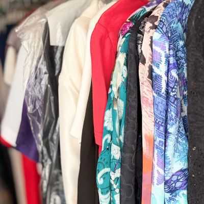 Sale Photo Thumbnail #156: Closet rack filled with various colorful women's clothing items.