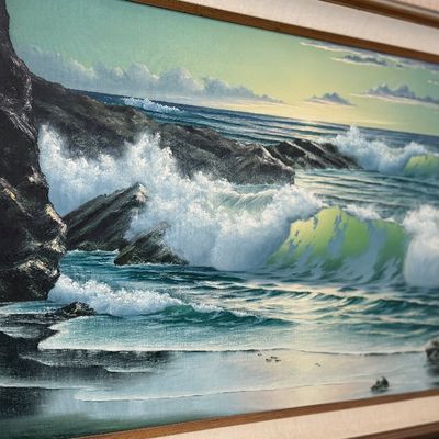 Framed oil painting of a coastal seascape depicting crashing ocean waves against dark rocks.
