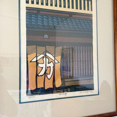 Sale Photo Thumbnail #106: Framed Japanese woodblock print depicting a traditional storefront with a noren curtain, pencil-signed and numbered 394/500.