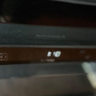 Black cable box with digital display and front-panel navigation controls.