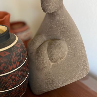 Abstract stone sculpture depicting a mother holding a child.