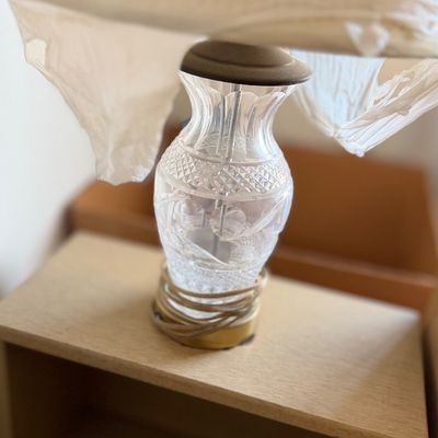 Cut crystal table lamp with a brass base and a wrapped lamp shade.