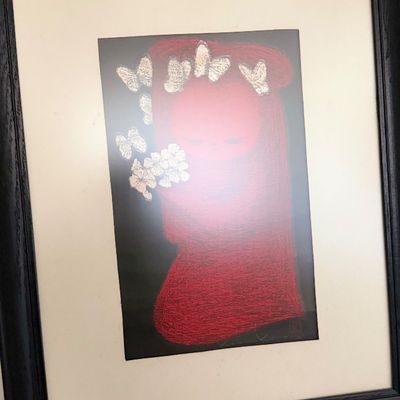 Framed artwork depicting a figure in red surrounded by butterflies.