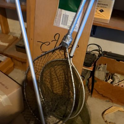 Sale Photo Thumbnail #168: Two fishing landing nets with aluminum handles leaning against storage boxes.