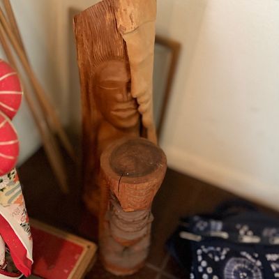 Hand-carved wooden sculpture depicting a face integrated into a log.