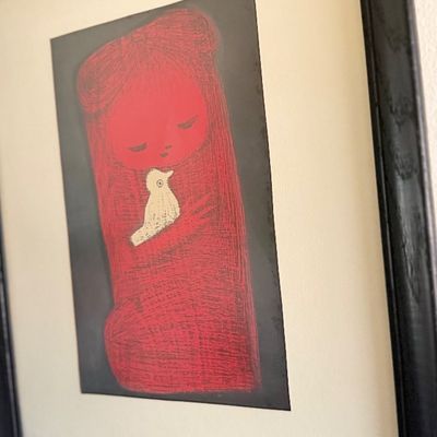 Framed mid-century style art print featuring a figure in red holding a white bird.