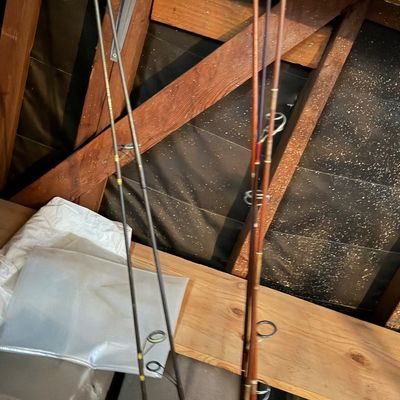 Sale Photo Thumbnail #170: Vintage fishing rods leaning against wooden shelving.