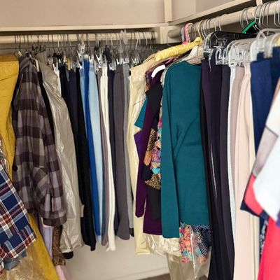 Sale Photo Thumbnail #157: Walk-in closet filled with hanging men's and women's clothing, including jackets, shirts, and trousers on multiple racks.