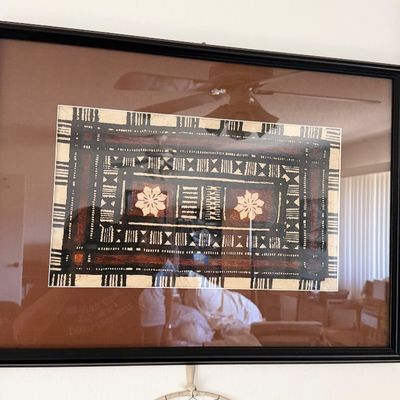 Sale Photo Thumbnail #144: Framed Pacific Island tapa cloth artwork featuring geometric patterns and flower motifs, set under glass in a black frame with a brown mat.