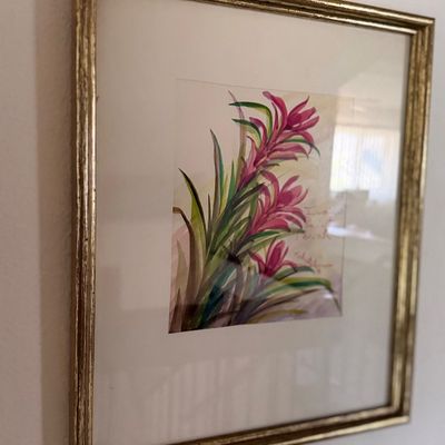 Sale Photo Thumbnail #104: Framed floral watercolor painting depicting pink bromeliad flowers set in a matted gold-finished frame.