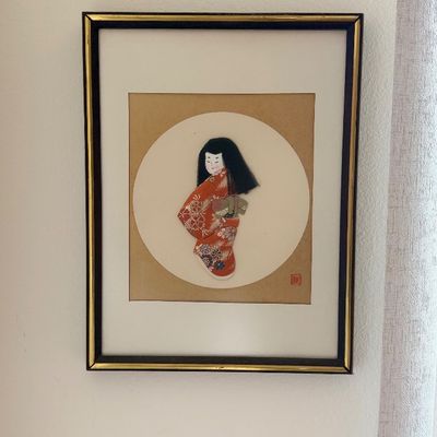 Framed Japanese fabric collage artwork depicting a figure in a red kimono.