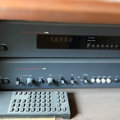 NAD Monitor Series Stereo Tuner 4100 and Monitor Series Stereo Preamplifier 1300 stacked with a Sony CD player remote.
