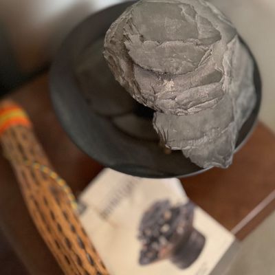 Tabletop faux stone electric water fountain in a dark dish, shown with manual and rainstick.