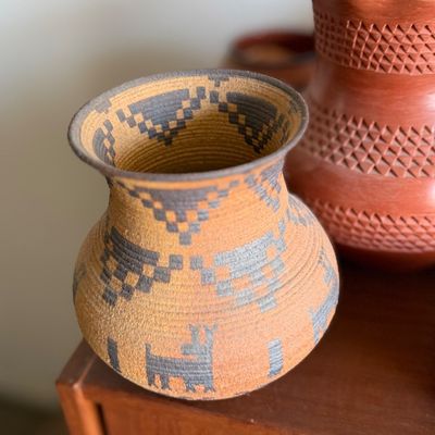 Southwestern-style pottery vase featuring geometric and animal motifs.