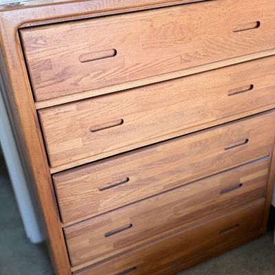 Sale Photo Thumbnail #114: Mid-century modern oak chest of drawers featuring five wide drawers with recessed cut-out handles and rounded frame edging.