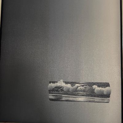 Framed contemporary artwork featuring a minimalist dark canvas with a small rectangular vignette of ocean waves.