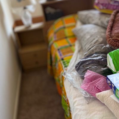Bed with a colorful plaid bedspread and assorted bedding items.