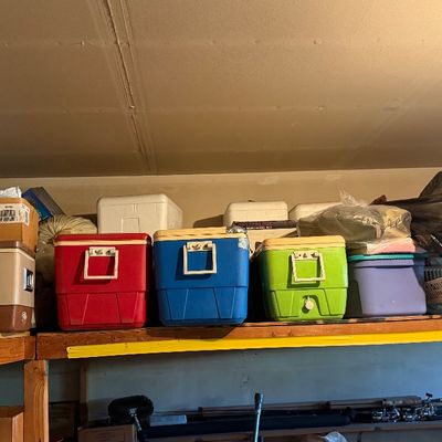 Sale Photo Thumbnail #177: Collection of vintage ice chests and plastic coolers displayed on garage storage shelving.