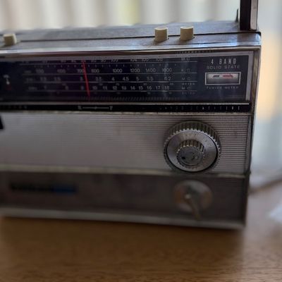 Vintage 4-band solid state portable radio with silver and black metallic trim.