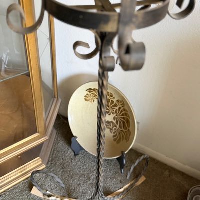 Vintage wrought iron plant stand featuring a twisted stem and scrolled accent details.