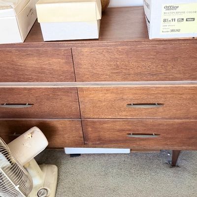 Sale Photo Thumbnail #117: Mid-century modern wooden six-drawer dresser with tapered legs and horizontal metal pulls.