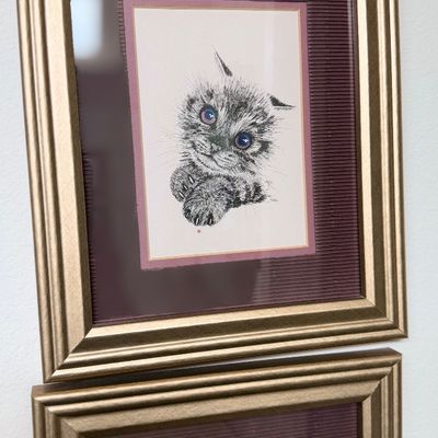 Sale Photo Thumbnail #153: Framed black-and-white print depicting a fluffy kitten with purple-tinted eyes, set in a double mat inside a molded gold-tone frame.