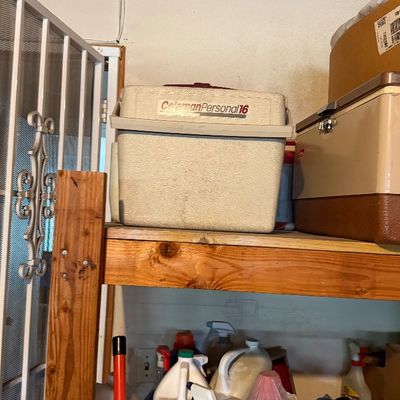 Sale Photo Thumbnail #172: Vintage Coleman Personal 16 cooler resting on a wooden shelf.