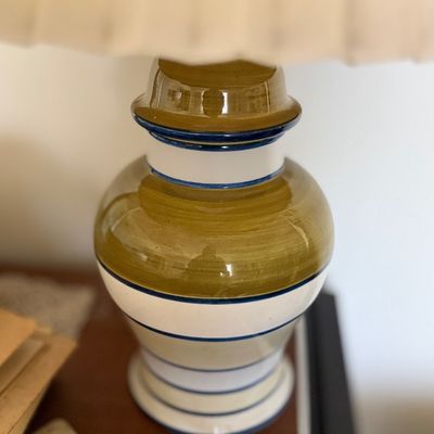 Sale Photo Thumbnail #142: Ceramic table lamp with a glazed green and white striped urn-style base and a pleated fabric shade.