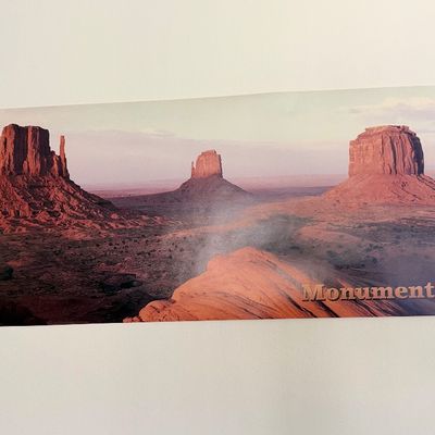 Sale Photo Thumbnail #124: Panoramic poster of Monument Valley featuring sandstone buttes mounted on a wall.