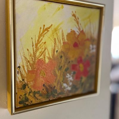 Sale Photo Thumbnail #102: Framed impressionistic floral oil painting depicting colorful wildflowers in warm yellow and orange tones, set in a thin gold metal frame.