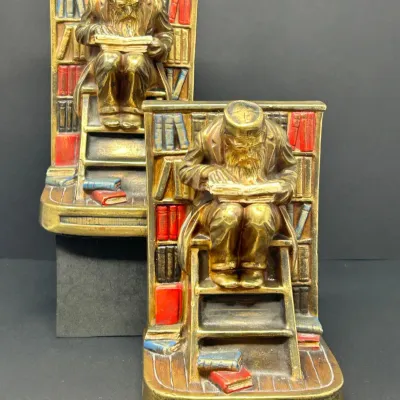 Sale Photo Thumbnail #55: Pair of vintage brass-finish bookends depicting a scholar seated on a library ladder reading a book, featuring painted bookshelf details.