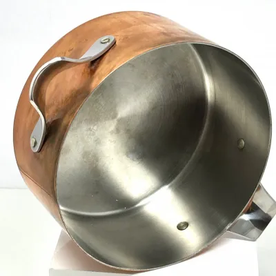 Sale Photo Thumbnail #40: Large copper stockpot with stainless steel lining and riveted side handles, showing minor surface wear from use.