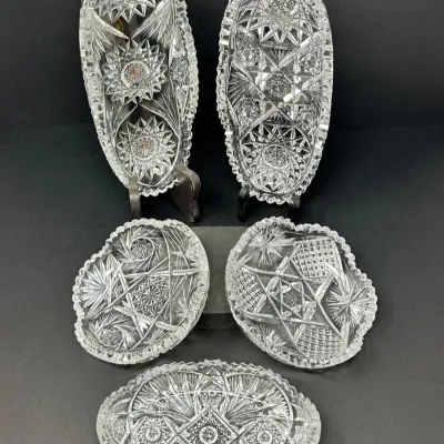 Sale Photo Thumbnail #195: Collection of five vintage American Brilliant Cut Glass oval relish dishes and serving bowls featuring intricate starburst and geometric geometric patterns.
