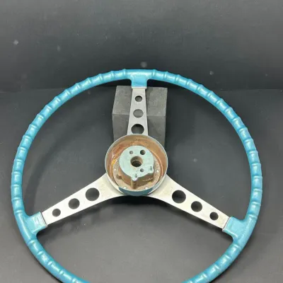 Sale Photo Thumbnail #30: Vintage three-spoke steering wheel with a bright blue grip, brushed metal spokes, and center mounting hub.