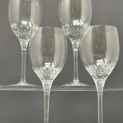 Sale Photo Thumbnail #28: Set of four crystal wine glasses featuring cut detail near the base of the bowl and tall, slender stems.
