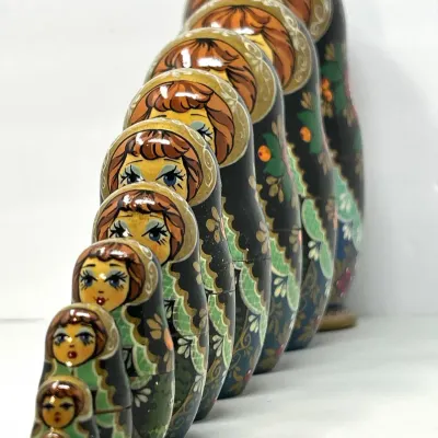 Sale Photo Thumbnail #138: Vintage ten-piece hand-painted Russian Matryoshka nesting doll set, lined up in size order with detailed floral folk art patterns.