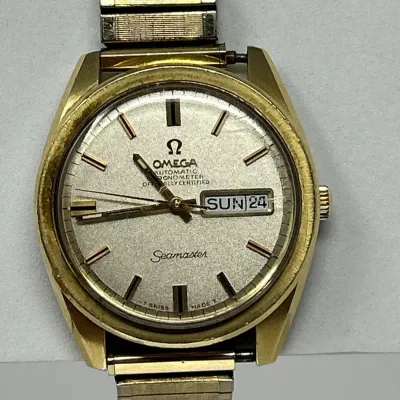 Sale Photo Thumbnail #39: Vintage Omega Seamaster Automatic Chronometer wristwatch in a gold-tone case with a day-date display window and textured expansion band.