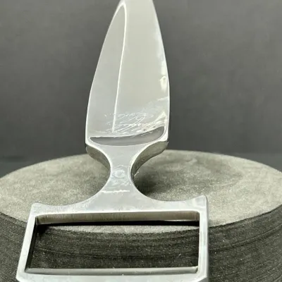 Sale Photo Thumbnail #43: Polished steel push dagger with an engraved maker's signature near the base of the blade, featuring a T-shaped handle integrated with a belt buckle mount.