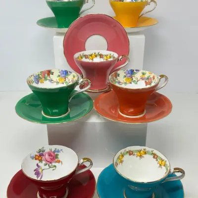 Sale Photo Thumbnail #133: Collection of vintage bone china teacups and saucers in vibrant solid colors with floral interior trims and gilt accents.